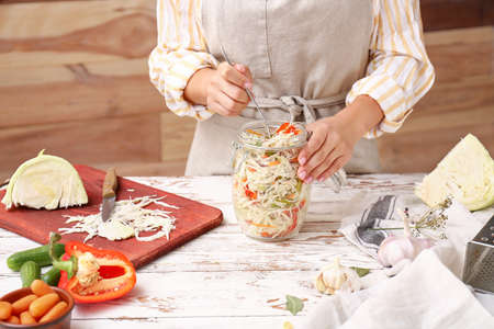 Woman preparing vegetables for fermentation at table, closeupの写真素材