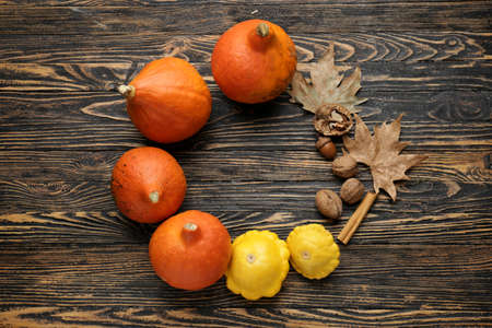 Autumn composition with fresh pumpkins and squashes on wooden backgroundの写真素材