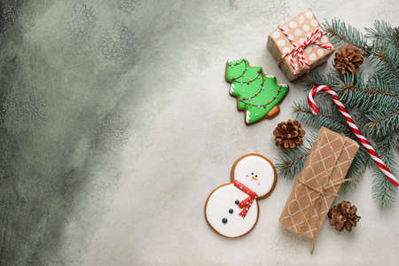 Tasty Christmas cookies with gifts on light backgroundの写真素材