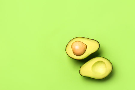 Halves of ripe avocado on color backgroundの写真素材