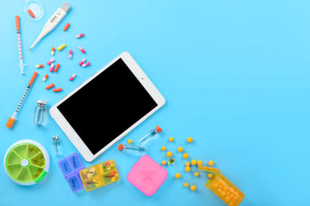 Tablet computer and pills on color backgroundの写真素材