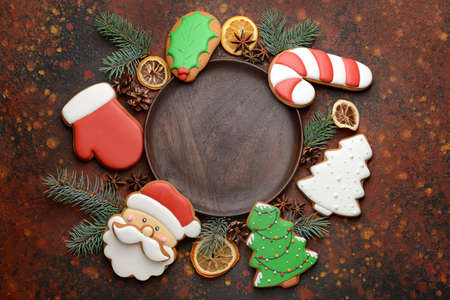 Plate with tasty Christmas cookies on color background