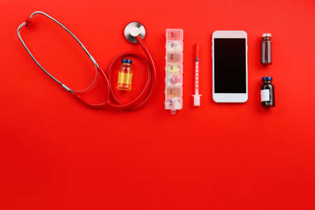 Modern mobile phone with doctor's supplies on color backgroundの写真素材