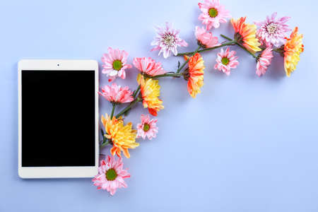 Modern tablet computer with flowers on color backgroundの写真素材