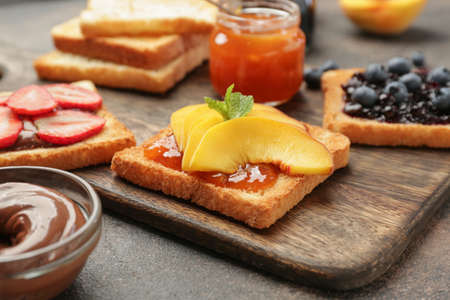 Different tasty sandwiches on wooden board, closeup