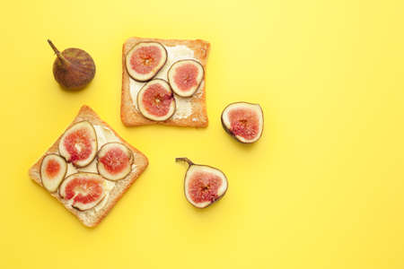 Tasty toasted bread with fig fruit on color background