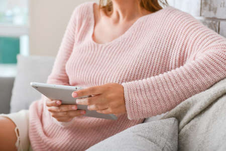 Woman with modern tablet computer at home, closeup