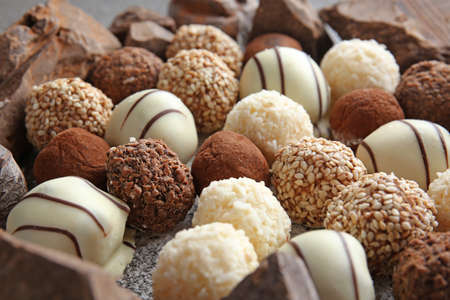 Tasty sweet truffles with chocolate on gray background