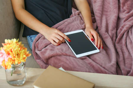 Young woman with modern tablet computer resting at home, closeup