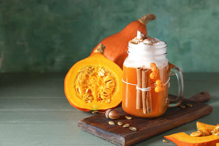 Mason jar of tasty pumpkin coffee on tableの写真素材