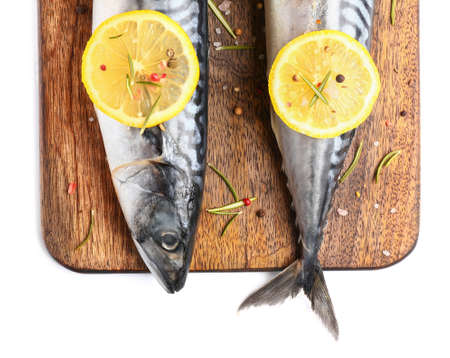 Board with raw mackerel fish and spices on white background