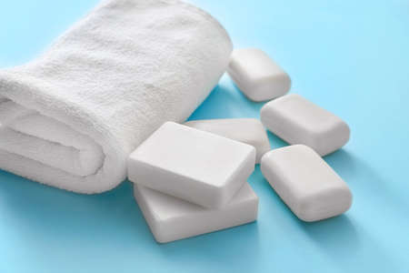 Soap and towel on color background