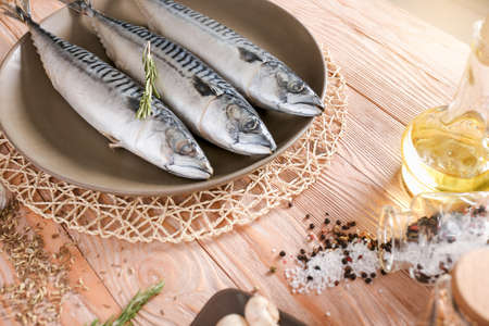 Plate with raw mackerel fish on wooden tableの写真素材
