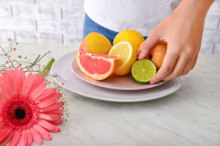 Woman with fresh fruits on table, closeupの写真素材