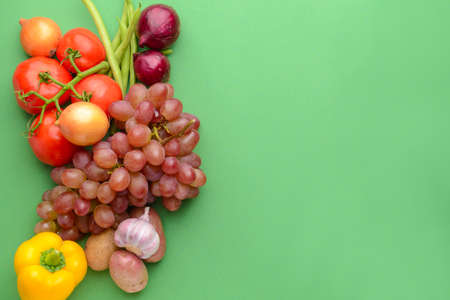 Many healthy vegetables with grapes on color backgroundの写真素材