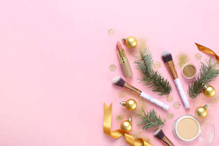 Set of cosmetics with makeup brushes and Christmas decor on color backgroundの写真素材
