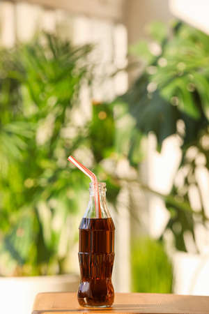 Bottle of cold cola on table indoorsの写真素材
