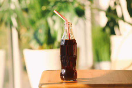 Bottle of cold cola on table indoors