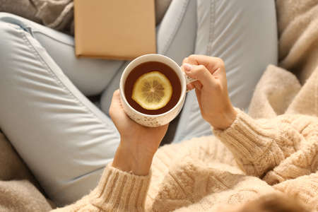 Young woman drinking hot tea at home