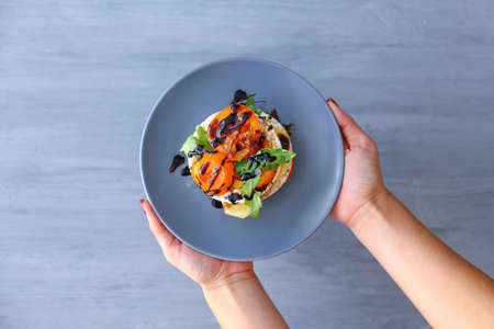 Woman holding plate with fresh vegetables and crispbread on plate, top viewの写真素材