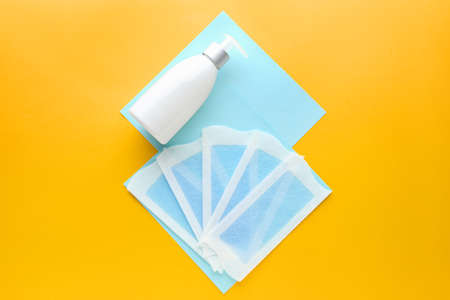 Wax strips for hair removal and cream on color backgroundの写真素材