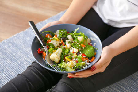 Woman holding bowl with fresh salad, closeupの写真素材