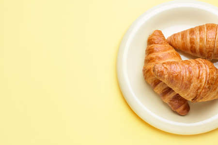 Plate with sweet croissants on color backgroundの写真素材