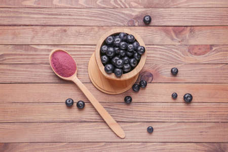 Acai berries with powder on wooden backgroundの写真素材
