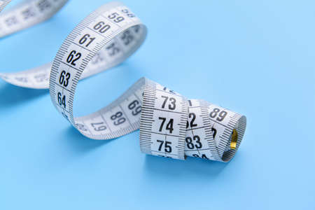 Measuring tape on color background