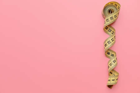 Measuring tape on color background