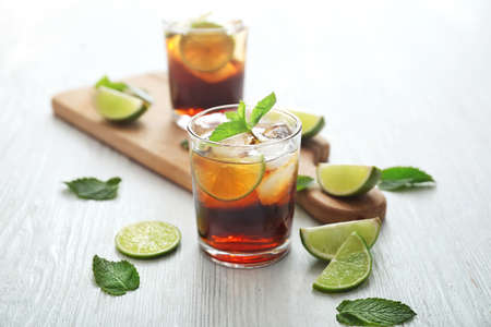Glass of cold cola, lime and mint on tableの写真素材