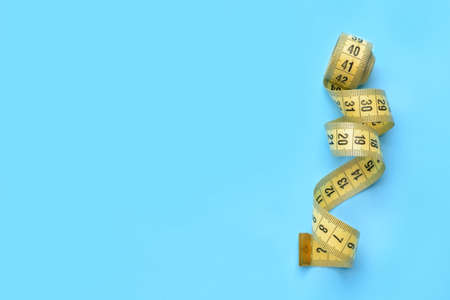 Measuring tape on color background
