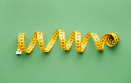 Measuring tape on color background