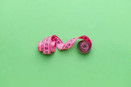Measuring tape on color background