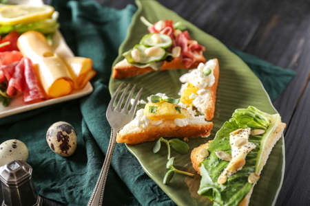 Plate with tasty sandwiches on dark tableの写真素材