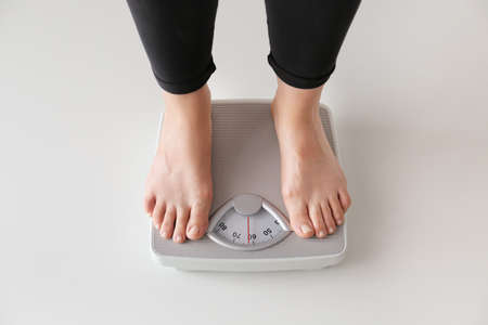 Woman standing on scales. Weight loss conceptの写真素材