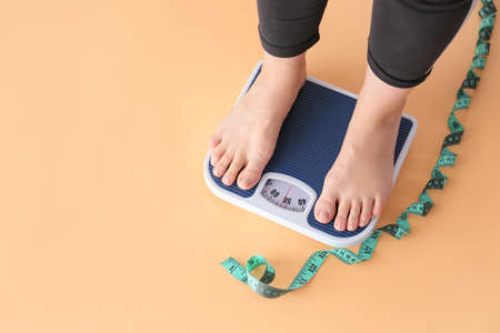Woman standing on scales. Weight loss conceptの写真素材