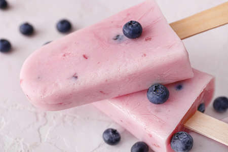 Tasty blueberry ice cream on color background, closeup