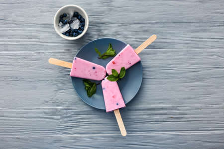 Plate with tasty blueberry ice cream on wooden table