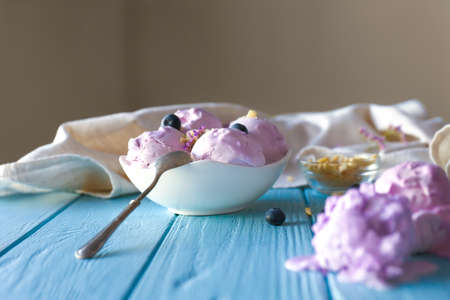 Tasty blueberry ice cream on wooden table