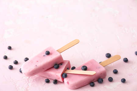 Tasty blueberry ice cream on color background