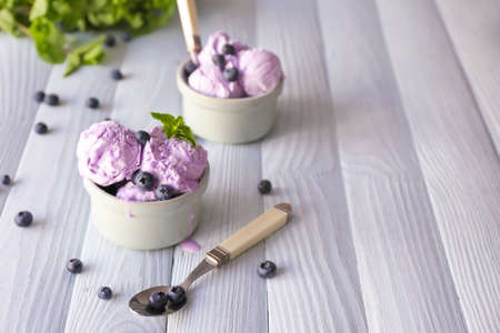 Bowls with tasty blueberry ice cream on wooden tableの写真素材