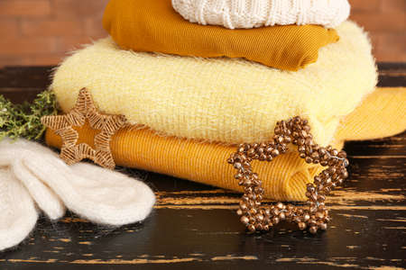 Winter clothes with Christmas decor on wooden table