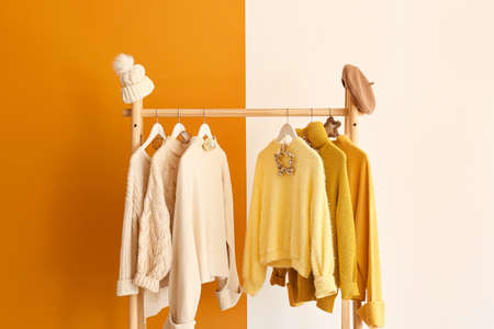 Rack with winter clothes on color backgroundの写真素材