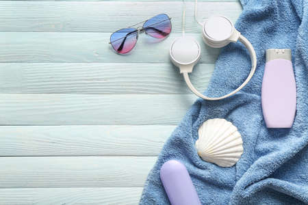 Summer composition with beach accessories, headphones and seashell on wooden background