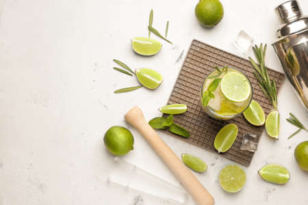 Glass of fresh mojito on light background
