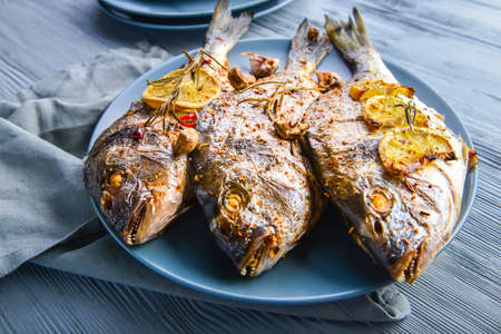 Plate with prepared dorado fish on wooden backgroundの写真素材