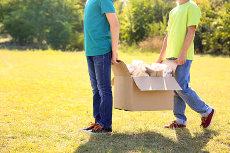 Boys gathering garbage outdoors. Concept of recycling