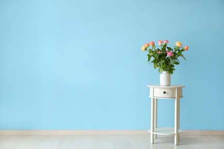 Vase with beautiful rose flowers on table in room