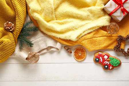 Warm clothes and Christmas decor on white wooden backgroundの写真素材
